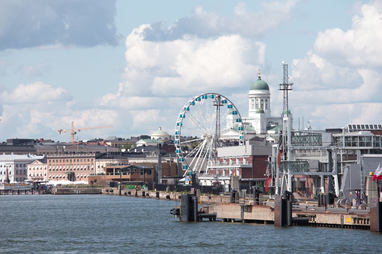 Scenic Helsinki waterfront featuring the Sky Wheel and iconic Helsinki Cathedral.